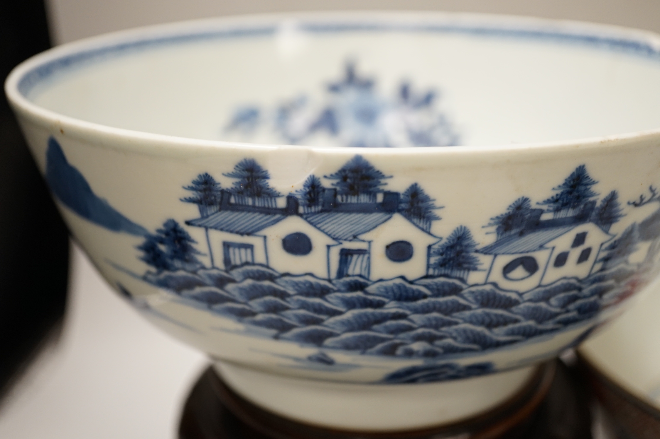 Four 18th century Chinese porcelain bowls (a.f), one with hardwood stand, largest 28cm diameter